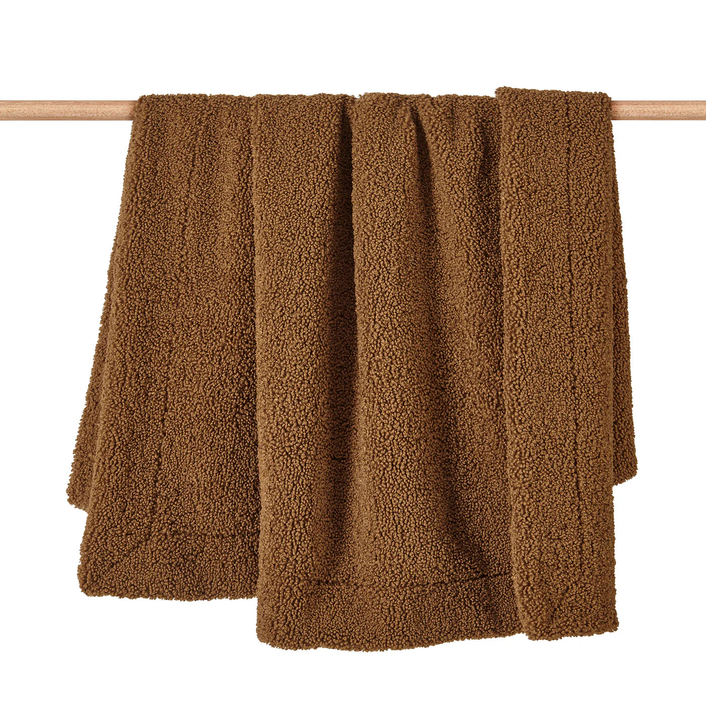 Teddy bear boucle throw blanket in brown with plush curled-loop woven texture, draped over a sofa